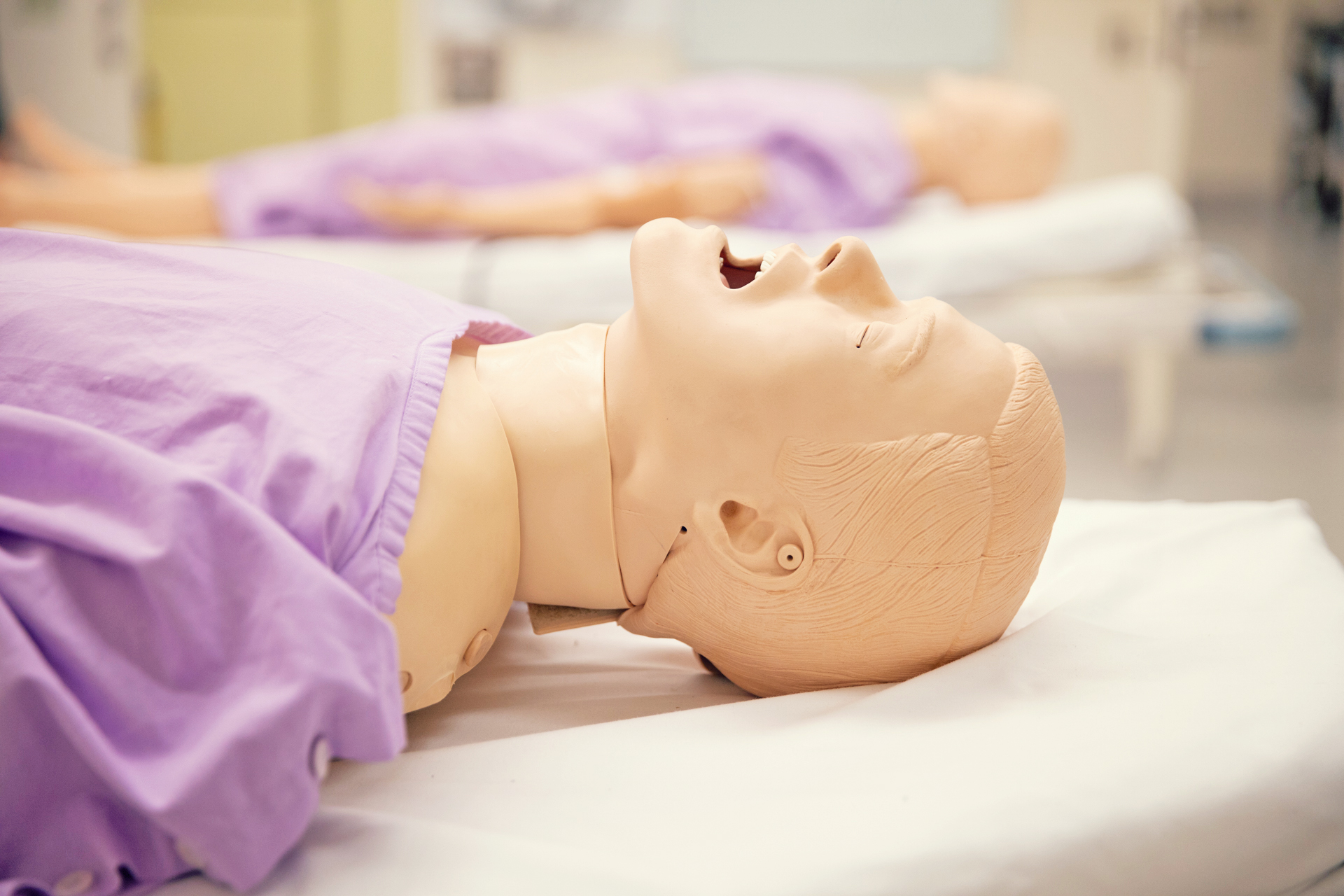 Medical simulation dummy lying on a hospital bed